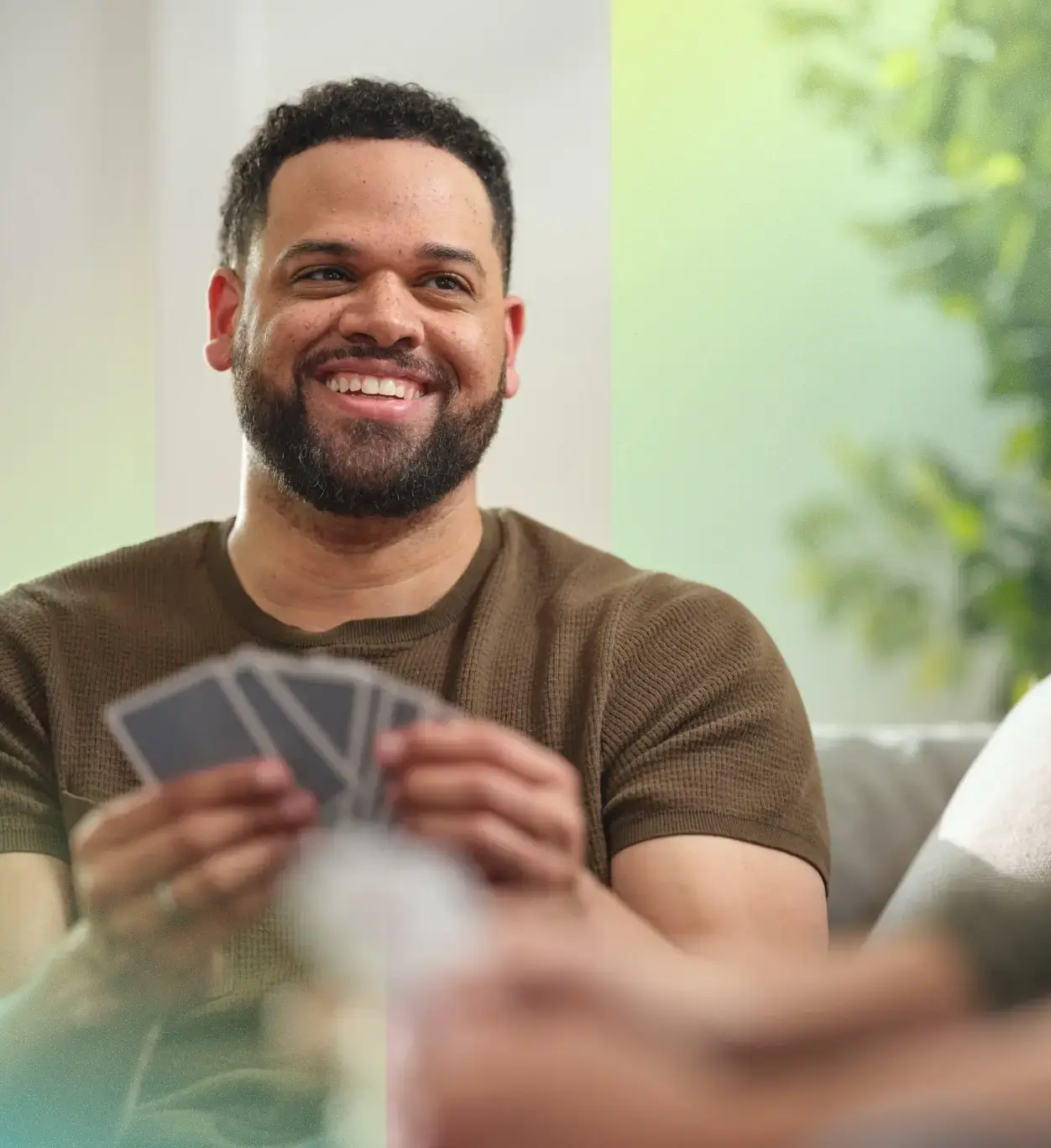 Smiling man playing a game of cards.