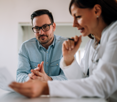 Healthcare provider reviewing her male patient's health screening results. 