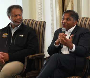 Two people seated in armchairs at a panel discussion in Richmond.