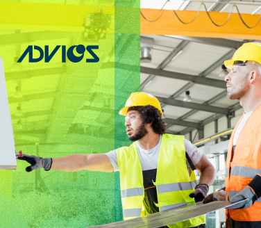 Two workers in hard hats and safety vests review a document inside an ADVICS facility