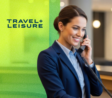 Smiling professional talking on a corded phone at a Travel + Leisure workplace
