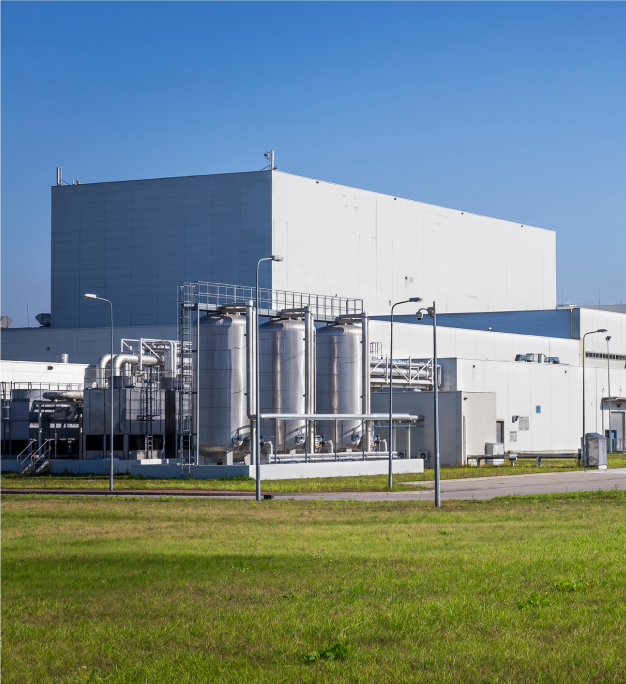 Franklin International industrial facility with stainless steel tanks and piping under a clear blue sky, surrounded by green grass.