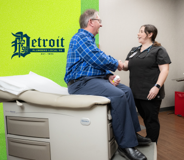 Person on an exam table shakes hands with a provider beside a Detroit Plumbers Local 98 logo