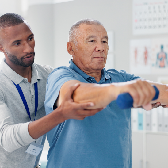 A seated person lifts a small dumbbell while another person supports their outstretched arm during an exercise