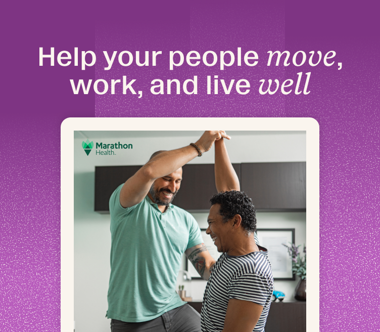 Two smiling people indoors, one guiding the other's arm overhead during a hands-on session, Marathon Health logo visible