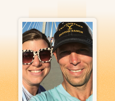 Brennan Killian smiling on a bridge in a Yellowstone cap and teal shirt, posing with another person