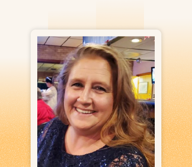Rhonda Dunn smiling in a navy sequined top at an indoor social gathering